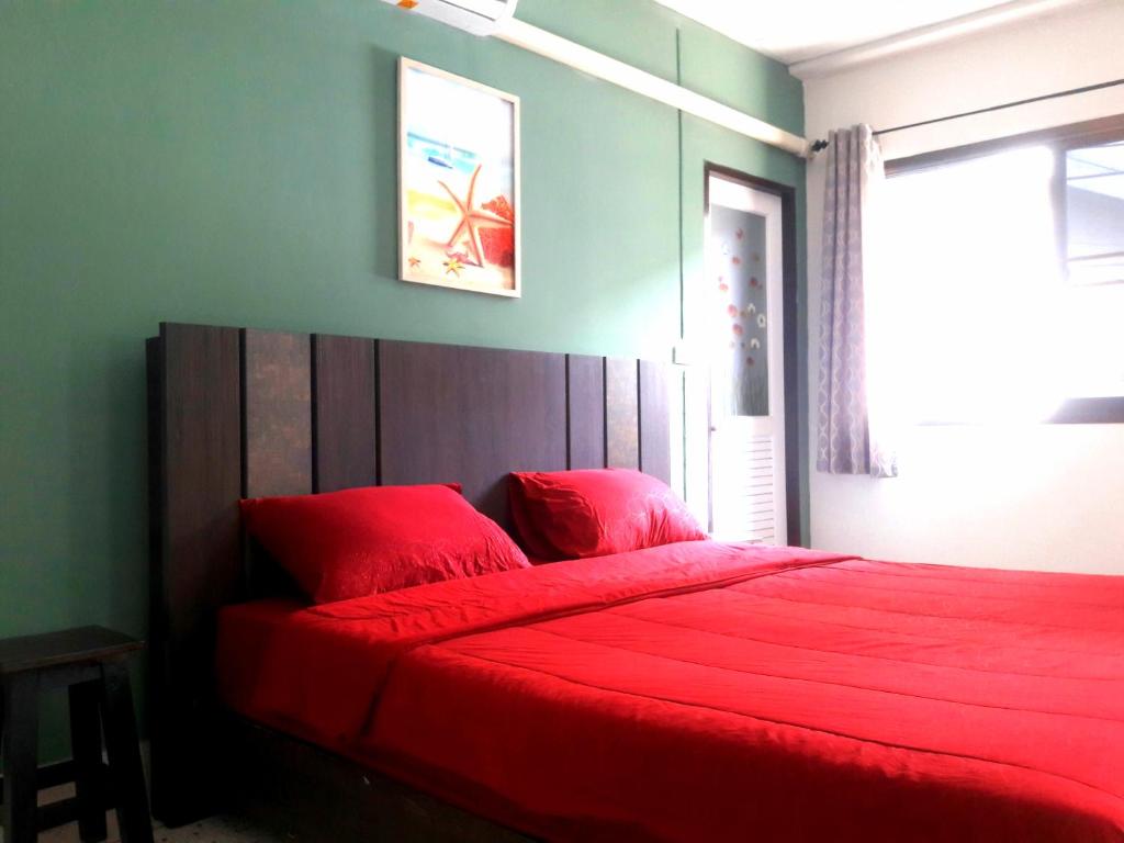 曼谷U&D guest house的一间卧室配有红色的床和红色毯子