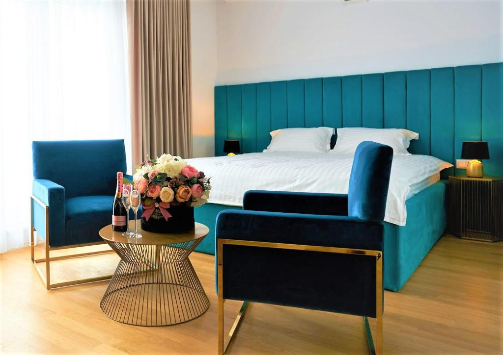 奥拉迪亚Hotel Glory的一间卧室配有一张床、一张沙发和一张桌子