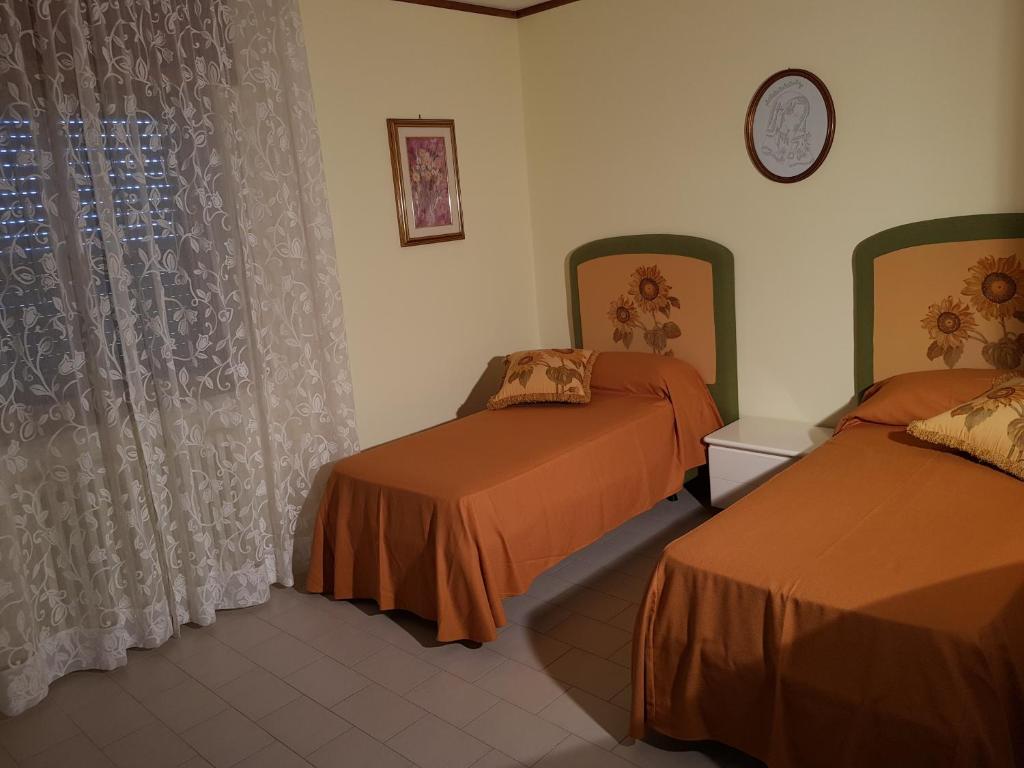 圣欧费米亚拉默齐亚Top bedroom GOLFO - Le Lincelle, Lamezia - 2 extra large single beds的酒店客房设有两张床和窗户。