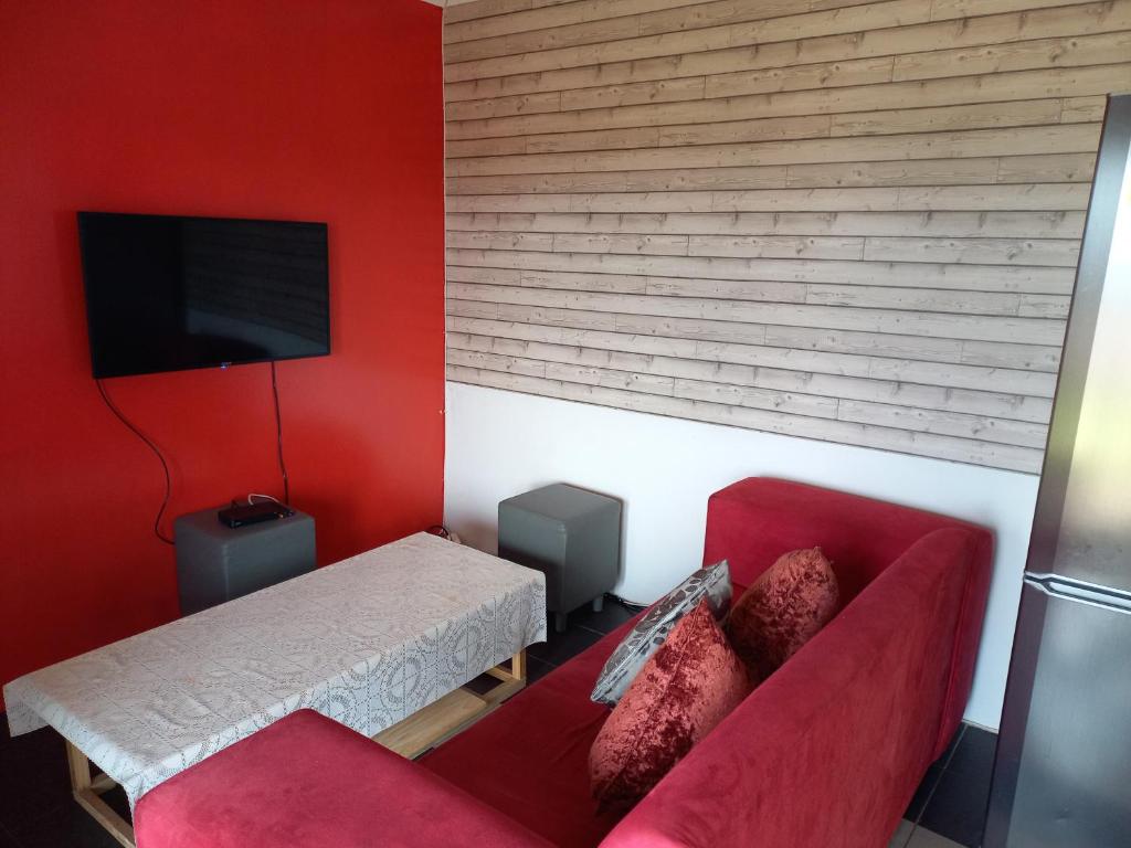 德班2 Bedroom Residential Home, along the coast.的红色的客厅配有沙发和电视