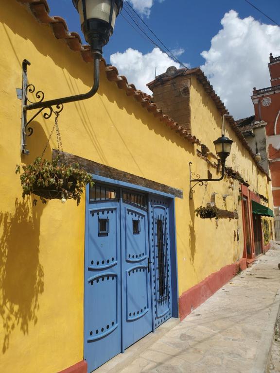 圣克里斯托瓦尔-德拉斯卡萨斯Casa Carmen的一条街上有蓝色门的黄色建筑