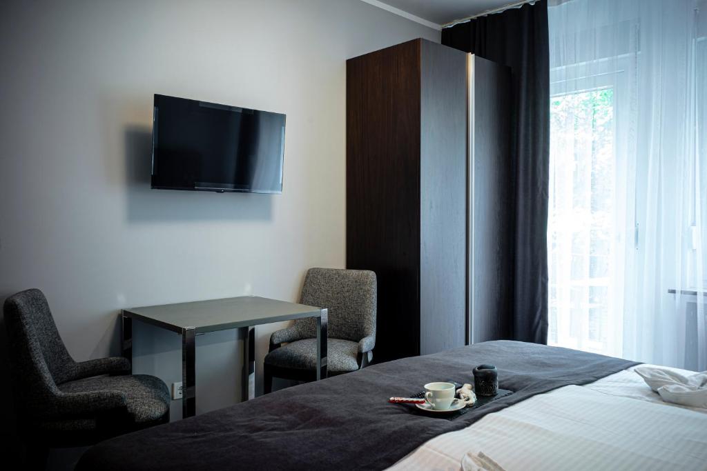 拉德福尔姆瓦尔德Löwen Hotel的一间酒店客房,配有一张床铺、一张桌子和一台电视