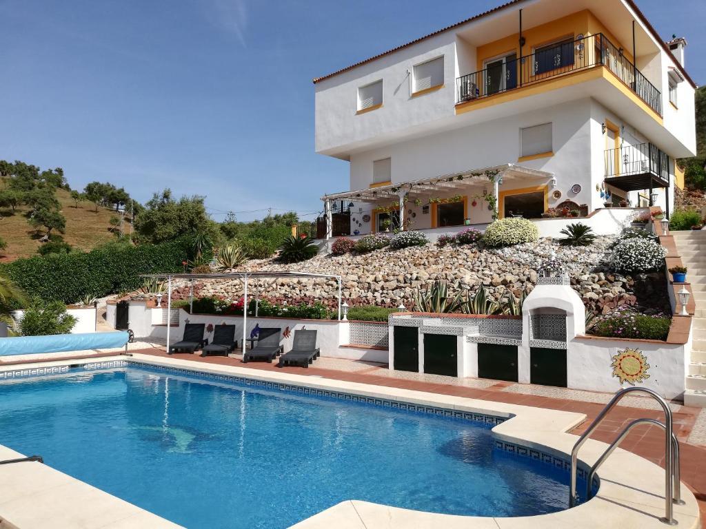 AlmogíaB&B Casa El Corasueño的一座别墅,在一座建筑前设有一个游泳池