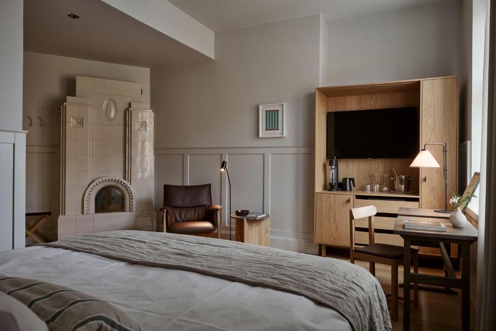 波尔沃RUNO Hotel Porvoo的一间卧室配有一张床、一张书桌和一台电视。