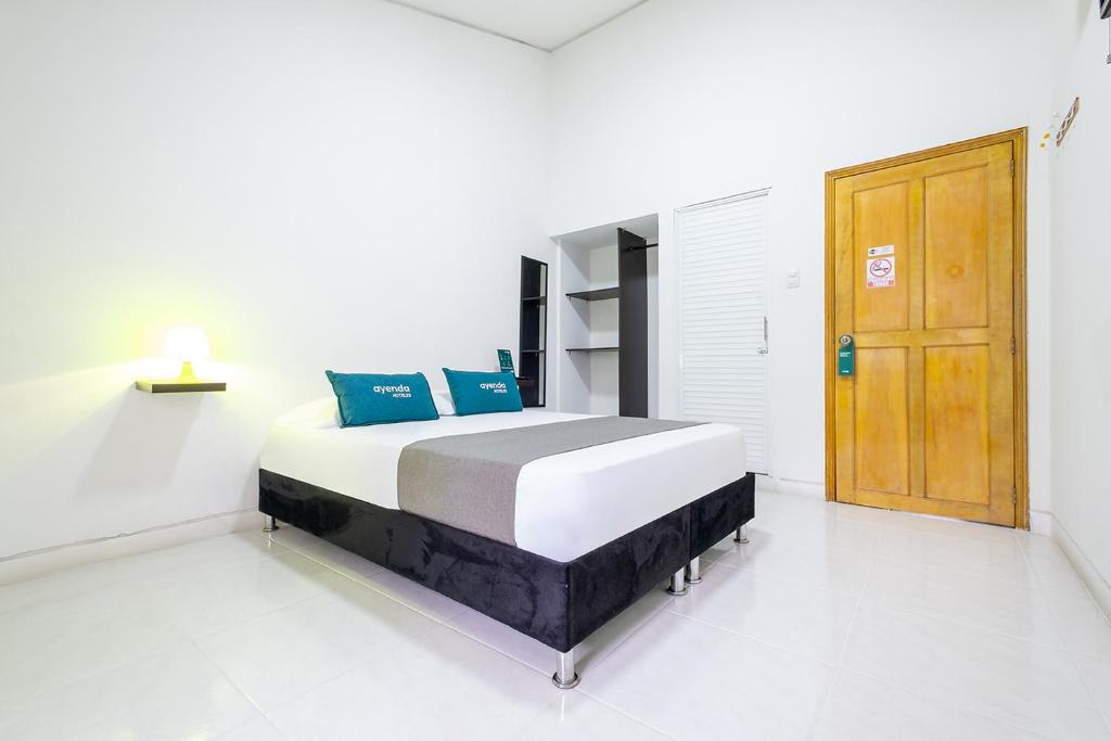 布卡拉曼加Ayenda Antiguo Campestre的一间卧室配有一张带蓝色枕头的床。