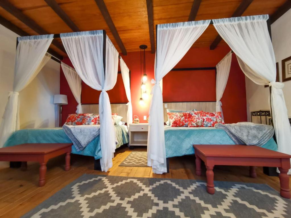 圣克里斯托瓦尔-德拉斯卡萨斯Corregidora 12的卧室设有两张床铺和红色的墙壁