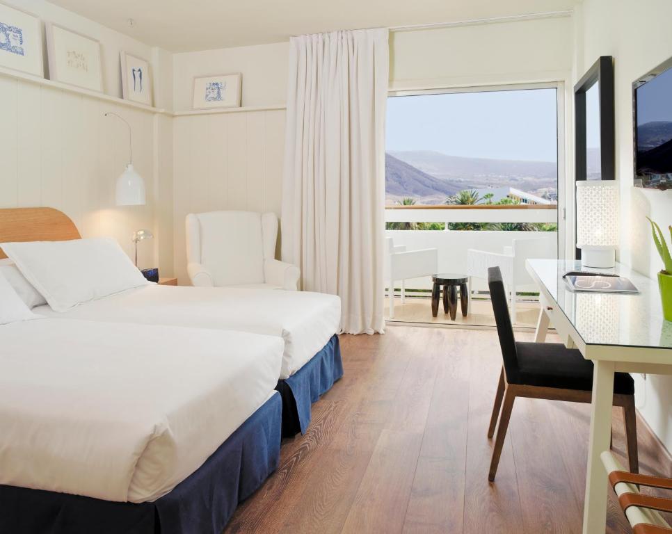洛斯克里斯蒂亚诺斯H10比格苏尔精品酒店 - 仅限成人的酒店客房配有一张床铺、一张桌子和一张书桌。