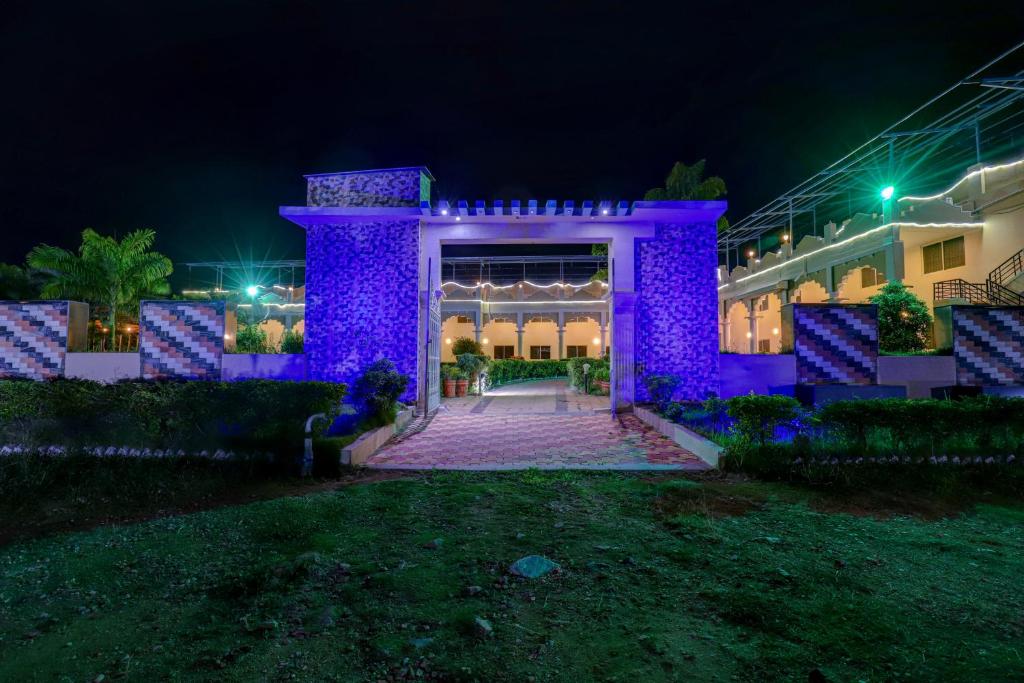 迈索尔Brindavan Garden Resort & Spa的一座晚上有紫色灯光的建筑