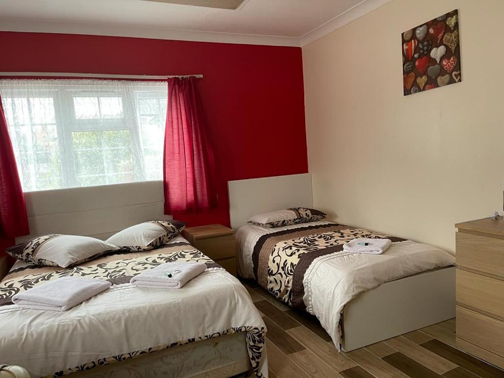 斯劳Nights Inn的卧室设有两张床铺和红色的墙壁