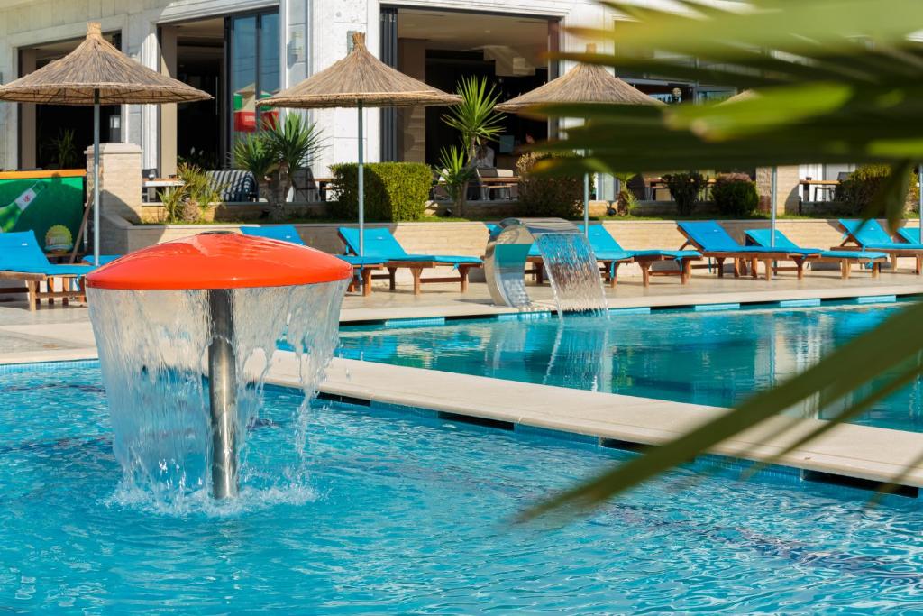 伏罗拉Kraal Hotel Vlore的游泳池中央的喷泉
