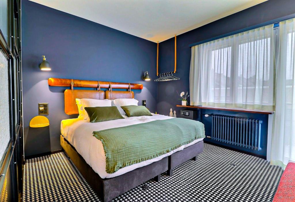 布勒Le Tonnelier的蓝色的卧室设有床和窗户