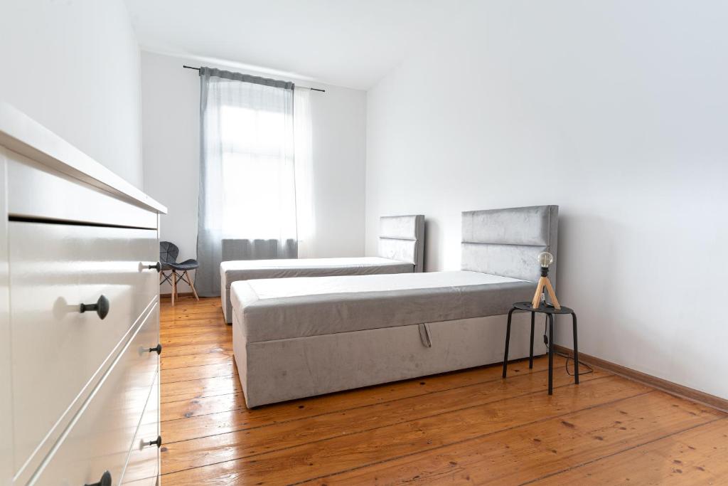 莱格尼察Avalon apart 2的一间铺有木地板的白色卧室,配有一张床