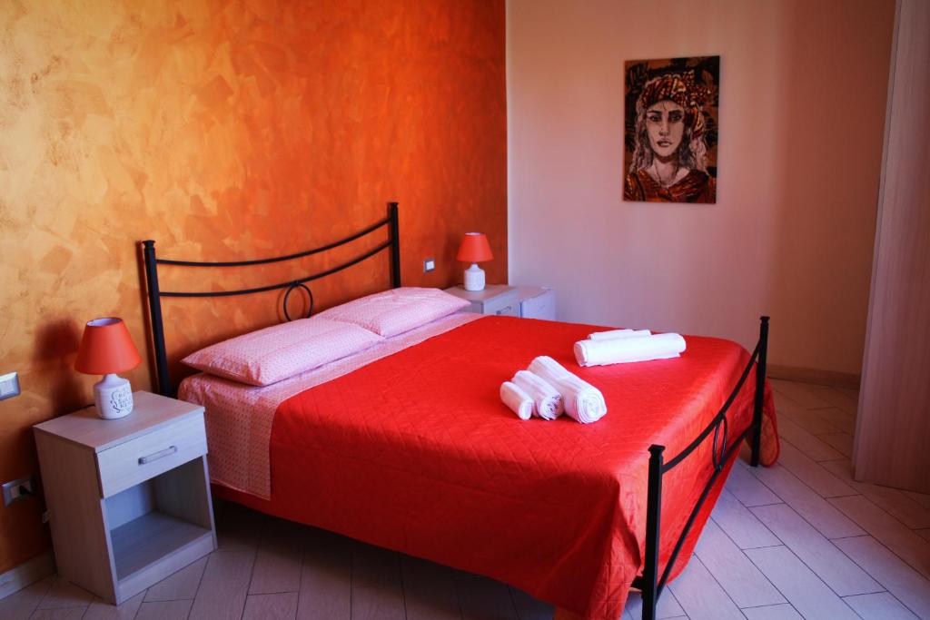 科森扎B & B Arcobaleno的一间卧室配有红色的床和2条毛巾