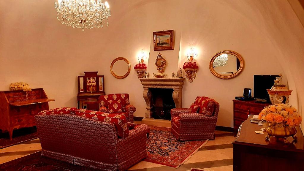 Rodengo SaianoCasa Giulia的客厅配有椅子、壁炉和吊灯。
