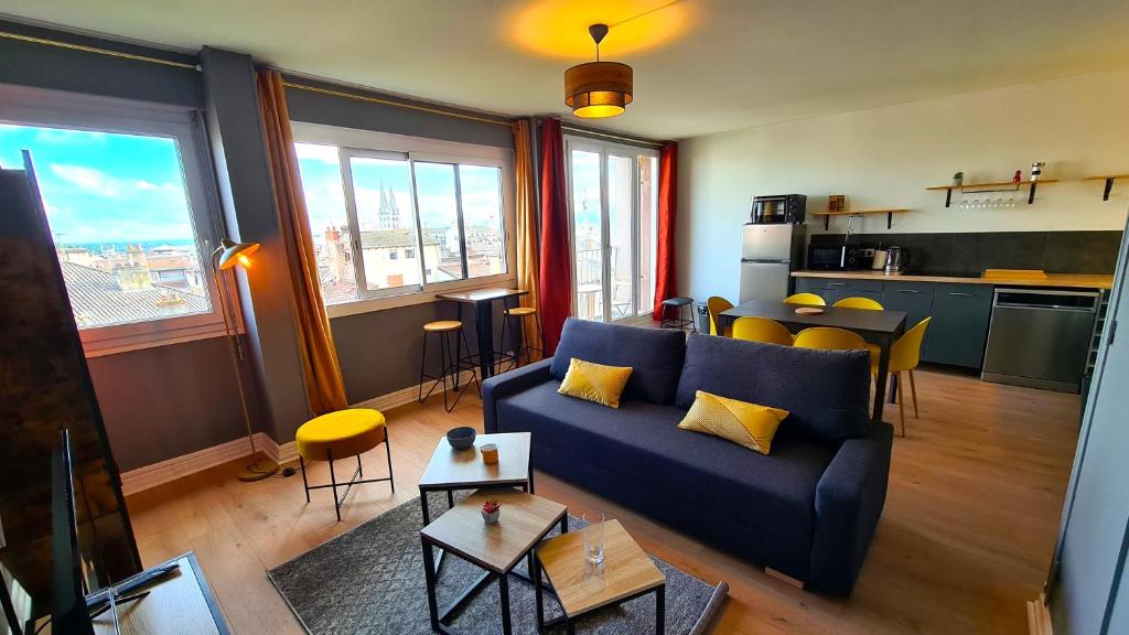 马孔Appartement Mâcon Centre T4 - 100m2的一间带蓝色沙发的客厅和一间厨房
