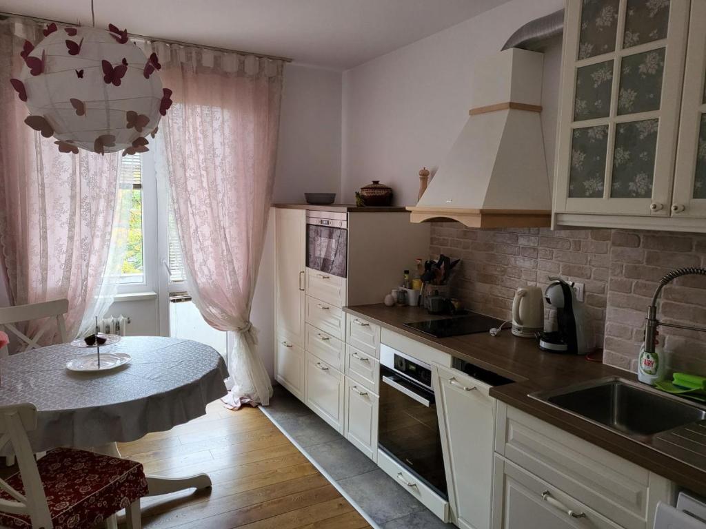 索非亚CasaBella Apartment的厨房配有白色橱柜、桌子和窗户。