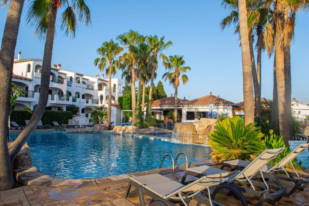 卡拉恩波特赛斯塔玛尔公寓的一个带椅子和棕榈树的度假游泳池