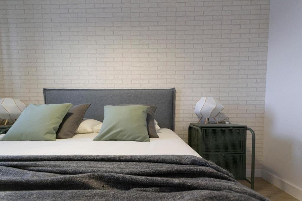 GandoEl encanto的卧室配有床和白色砖墙