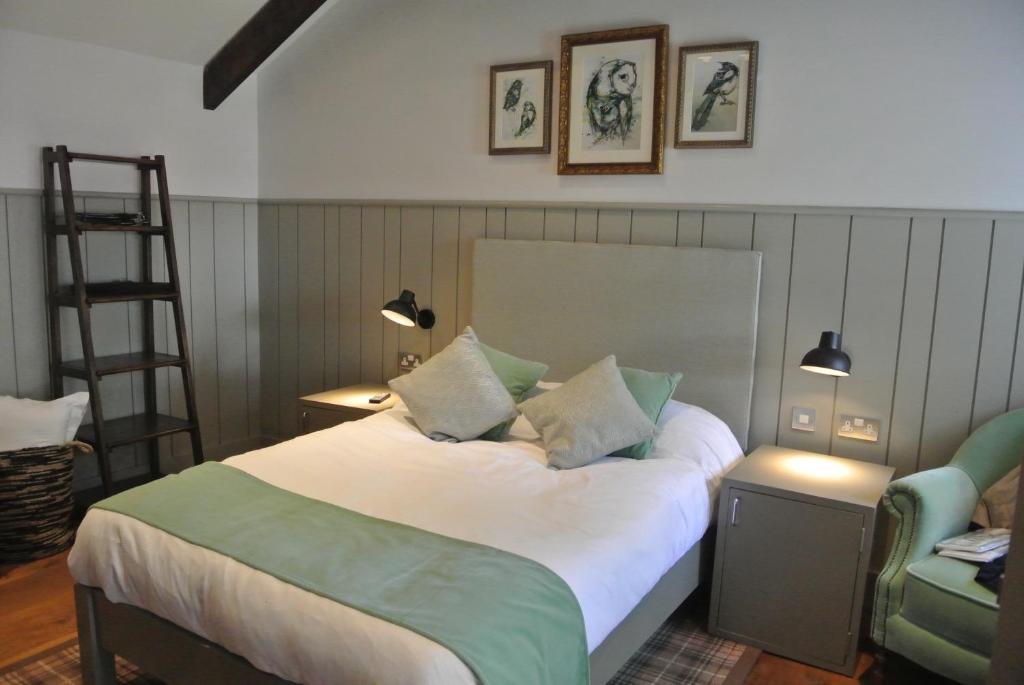亨洛皇冠酒馆、餐厅及住宿宾馆的一间卧室配有一张带梯子和椅子的床