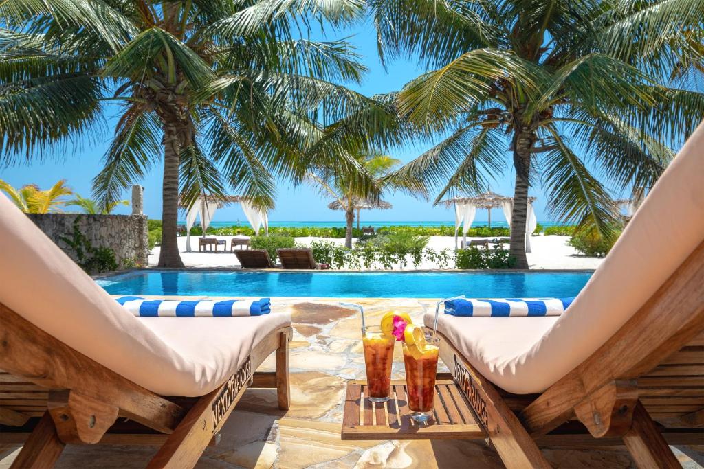 普瓦尼梅查恩加尼下一站天堂精品度假酒店的一个带游泳池和棕榈树的度假村