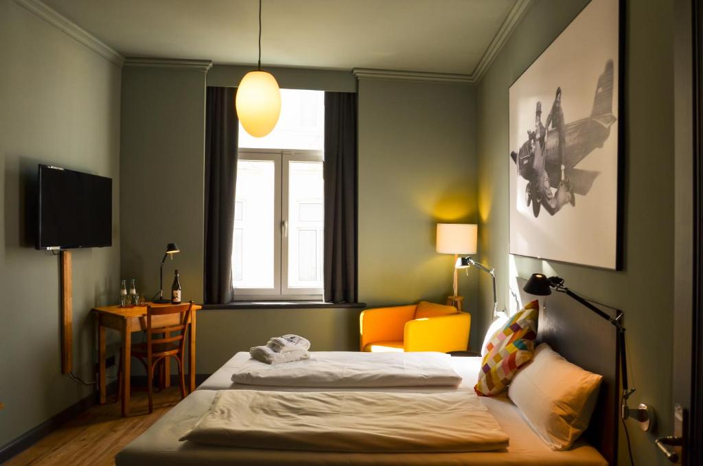 柯尼希斯温特Storyhotel Bergischer Hof Königswinter的酒店客房设有两张床和窗户。