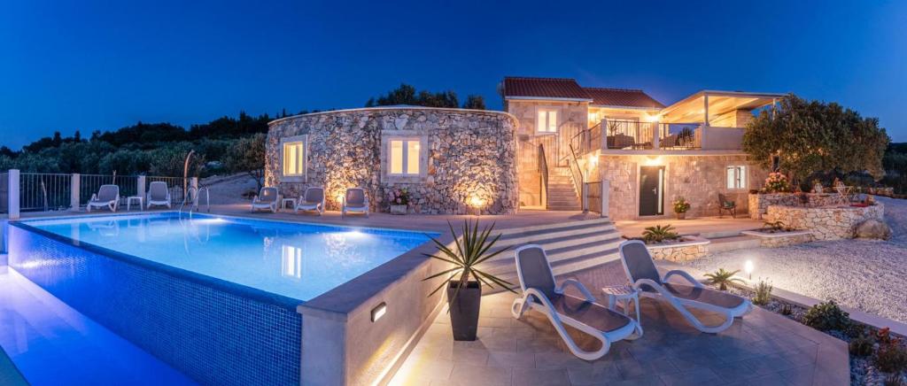 苏佩塔尔Villa Lukrecija Stonehouse的房屋前设有游泳池的房屋