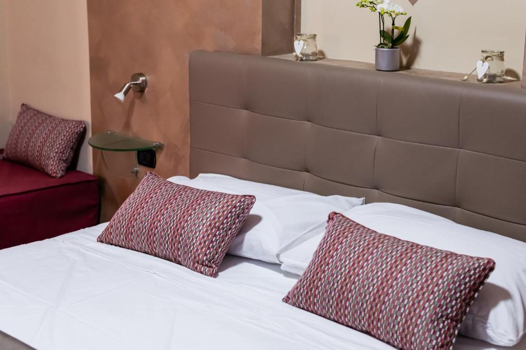 那不勒斯Royal Poerio的一张带两个红色和白色枕头的床