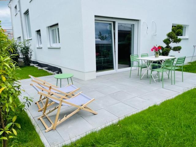 迪森阿姆阿梅尔塞Ammersee Haus in Haus,wunderschöne Designerferienwohung mit Garten的庭院配有桌椅和桌椅