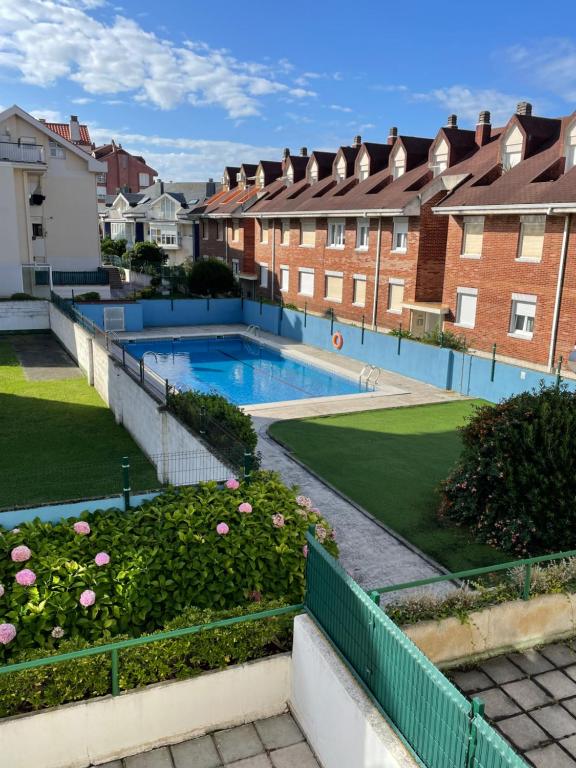 擞莫Apartamento con piscina y WIFI a 100 metros de la playa en Somo的一个带房屋的庭院内的游泳池