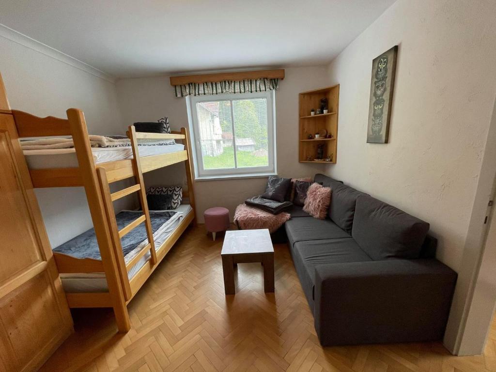 LukanjaAPARTMA ODKLOP Rogla的带沙发和双层床的客厅