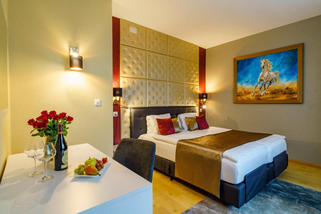 穆尔格Seeblick SMART Hotel Rössli的酒店客房,配有一张床和一张桌子,还有一碗水果