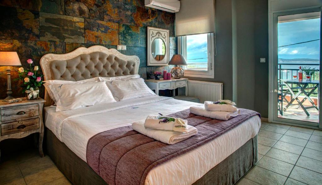 萨索斯Villa Teresa Luxury Suites的一间卧室配有一张大床和毛巾