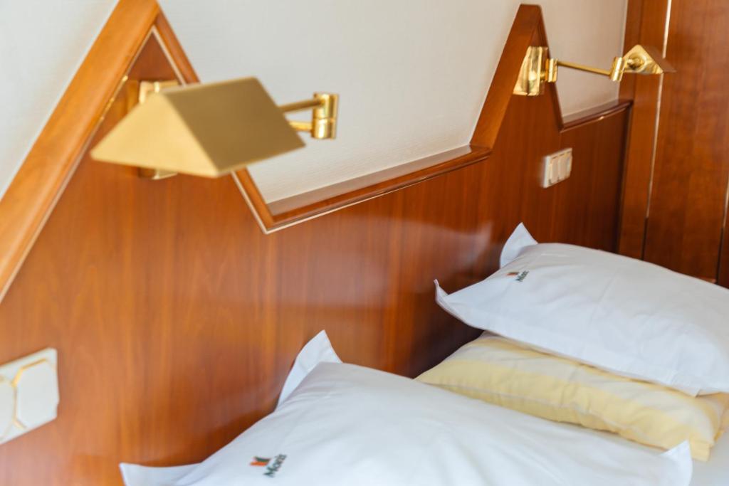 瓦尔弗当日莫里斯餐厅酒店的一间卧室配有一张带台灯和枕头的床