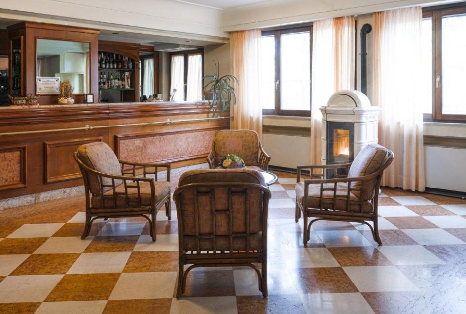 PalenaHotel Terrazzo d'Abruzzo的一间带椅子和桌子的房间以及壁炉