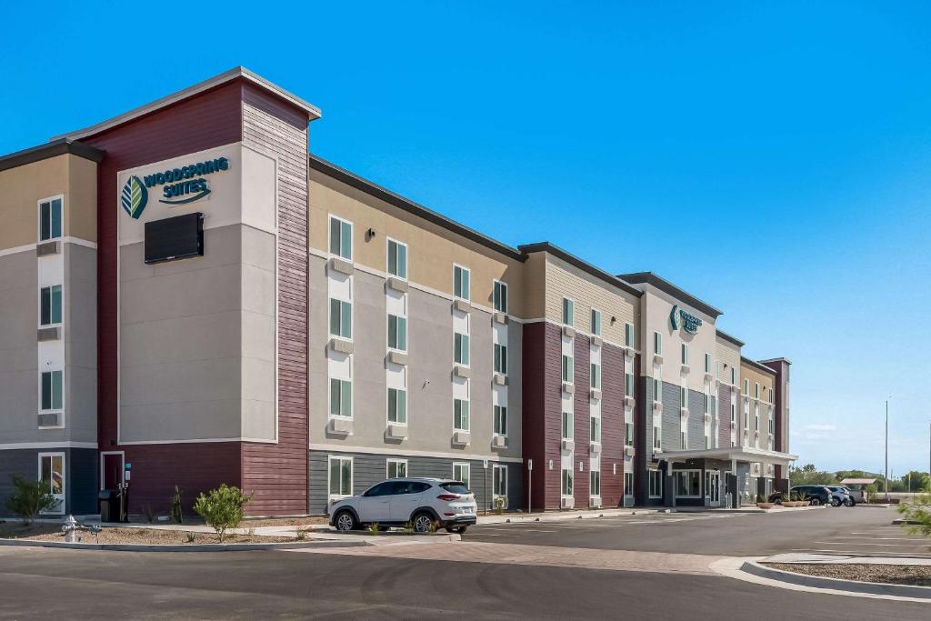 土桑WoodSpring Suites Tucson-South的停在大楼前的汽车