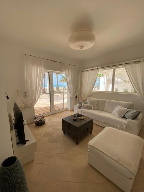 CabeçadasVilla Nº 25 Alfredo Marchetti Suites on the Beach,Praia de Chaves BV的客厅配有白色沙发和电视