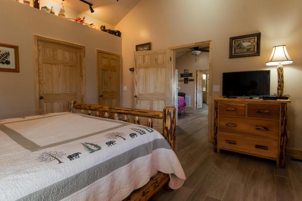 布赖森城卡尔霍恩之屋旅馆及套房酒店的一间卧室配有一张床和一台平面电视
