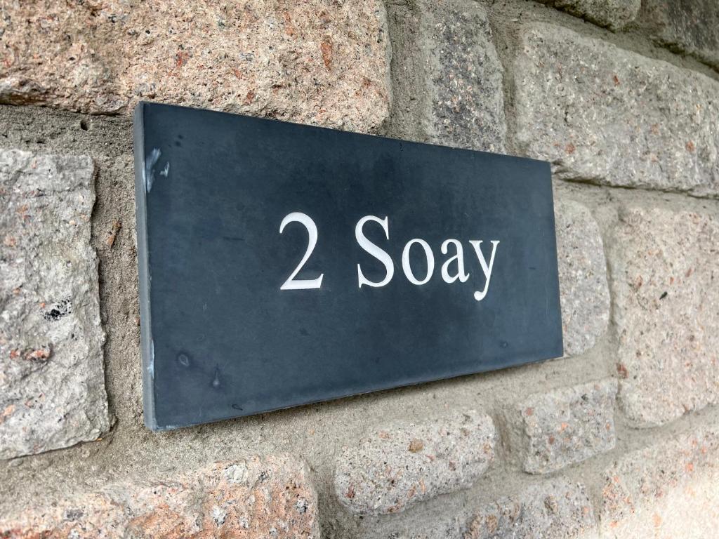 蒂恩格Soay@Knock View Apartments, Sleat, Isle of Skye的一块砖墙上的 ⁇ 音
