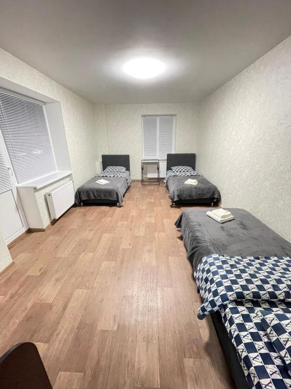切尔尼戈夫Апартаменты Проспект Победы 101的客房设有三张床,铺有木地板。