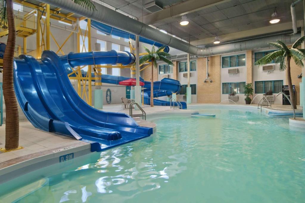 温尼伯Travelodge by Wyndham Winnipeg的一座大楼内带水滑梯的游泳池