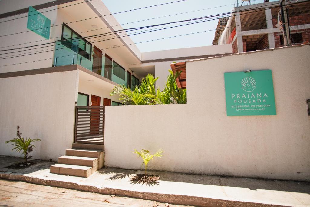 嘎林海斯港Pousada Praiana的建筑的一侧有绿色标志
