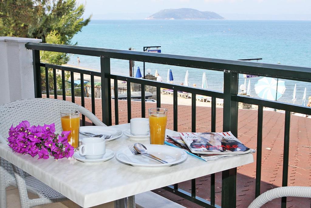 新马尔马拉斯米拉马雷公寓式酒店的海滩阳台的桌子上摆放着食物和饮料