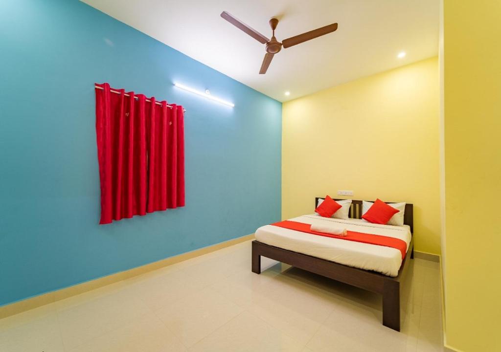 蓬蒂切里Aashikha Farm House的一间卧室配有一张带红色窗帘的床