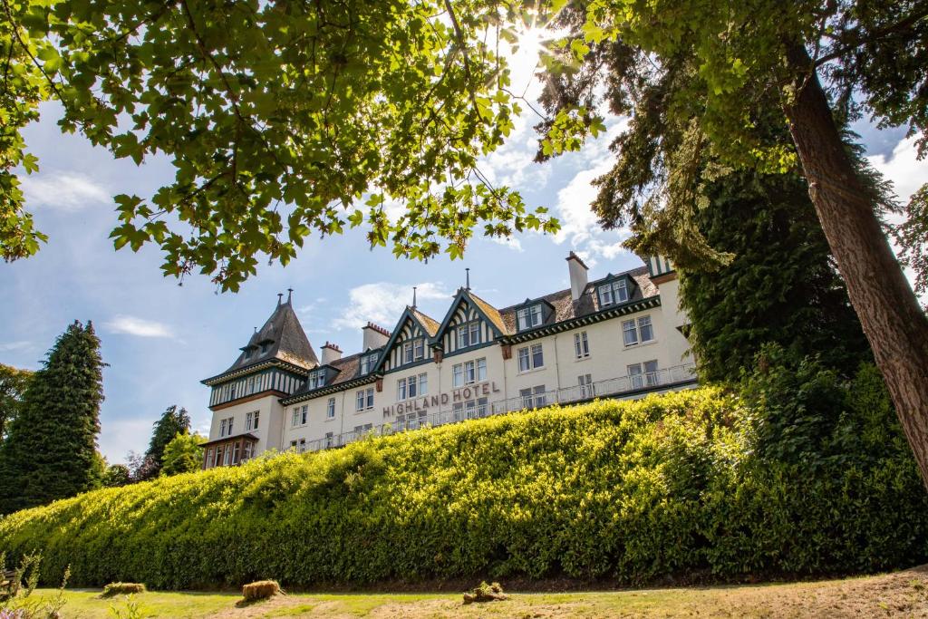 斯特拉斯佩弗The Highland Hotel by Compass Hospitality的一座树木茂密的山丘上的白色城堡