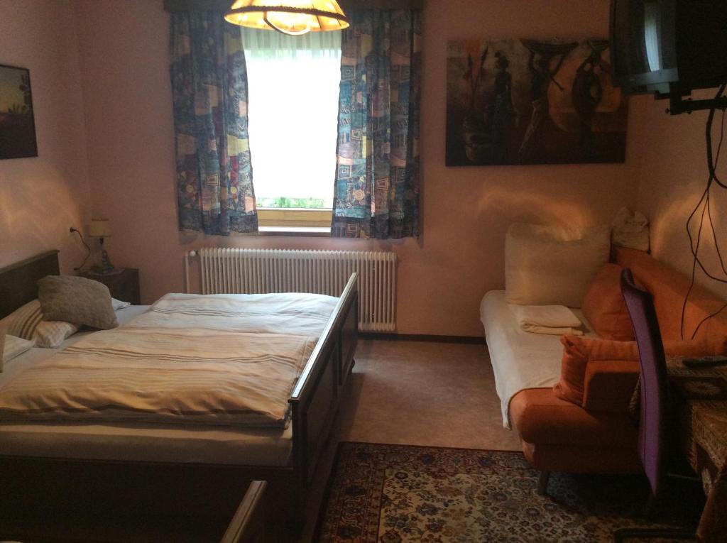 RantenMooswirt的一间卧室配有一张床、一张沙发和一个窗口
