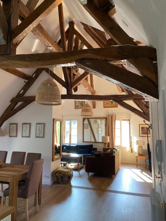 布尔日Aux 3 Maillets的一间带木制天花板的客厅和一间带沙发的房间