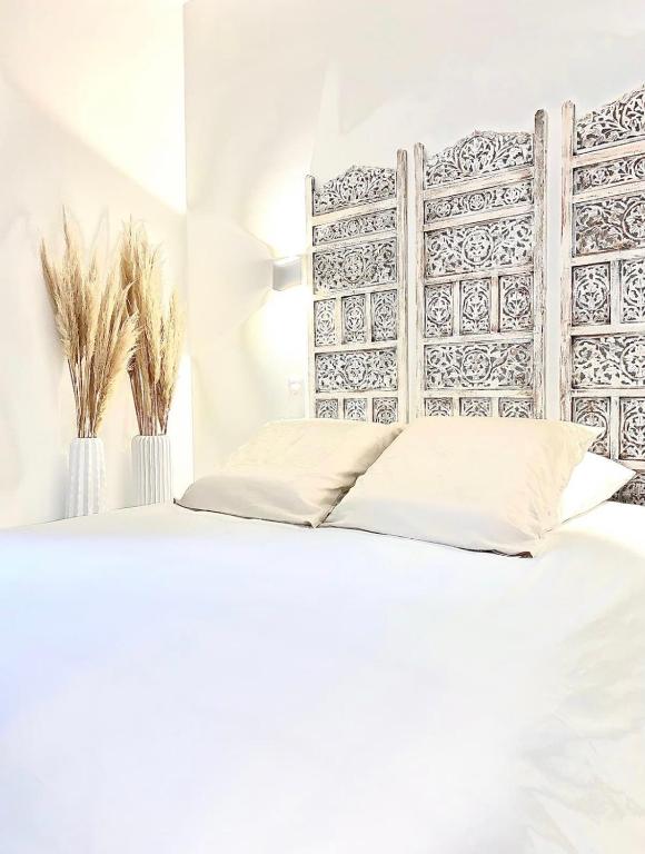 圣艾蒂安L’Escale - Le Boho + garage + NETFLIX的卧室配有白色的床和木制床头板