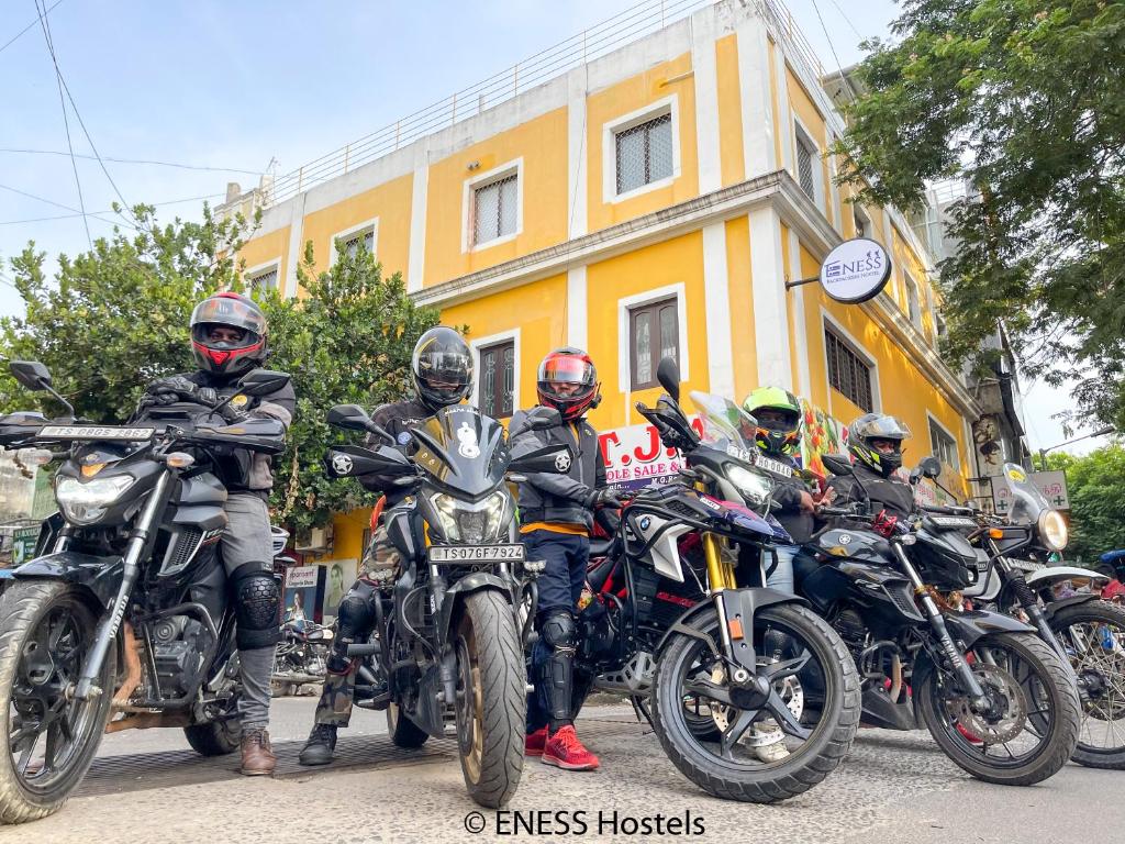 蓬蒂切里Eness Hostels Pondicherry的一群骑摩托车的人停在大楼前