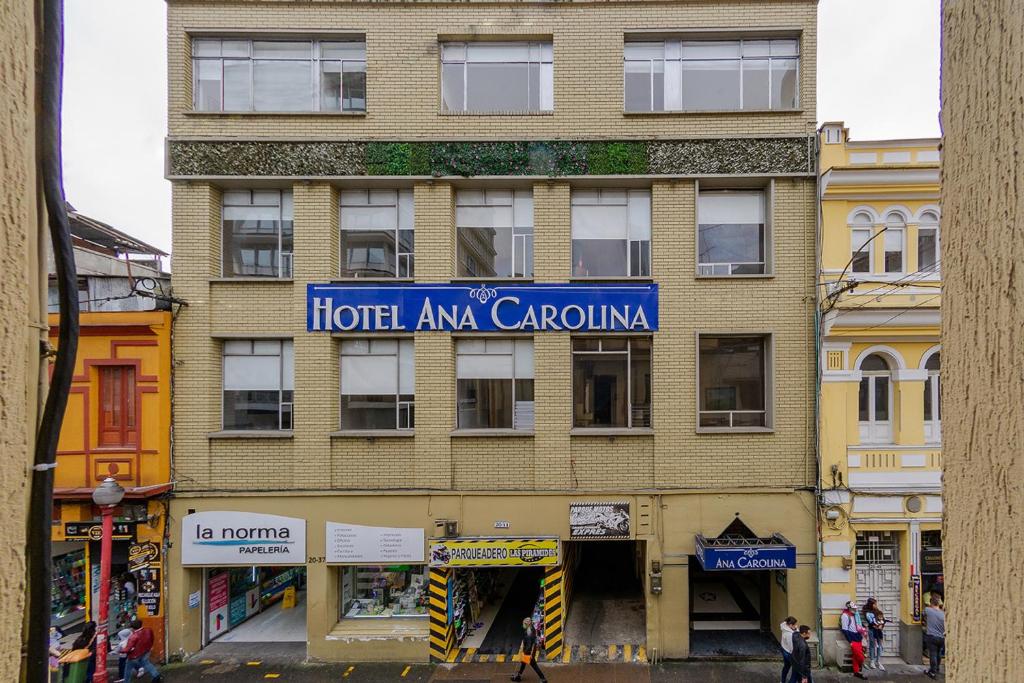 马尼萨莱斯Hotel Ana Carolina的一座高大的砖砌建筑,上面有标志