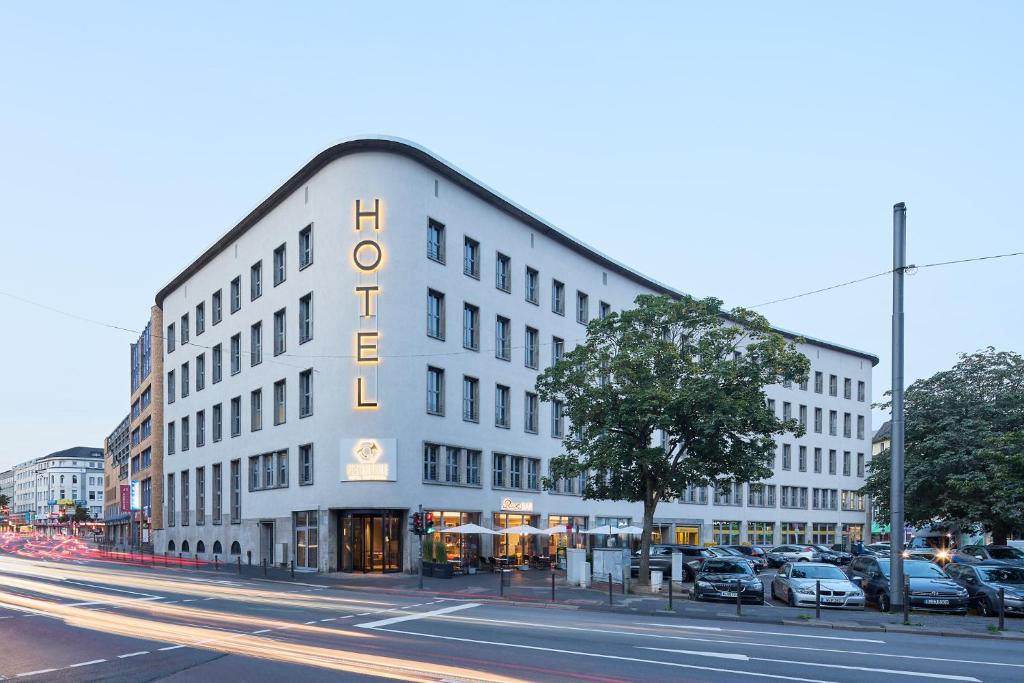伍珀塔尔Postboutique Hotel Wuppertal的白色的建筑,旁边标有标志